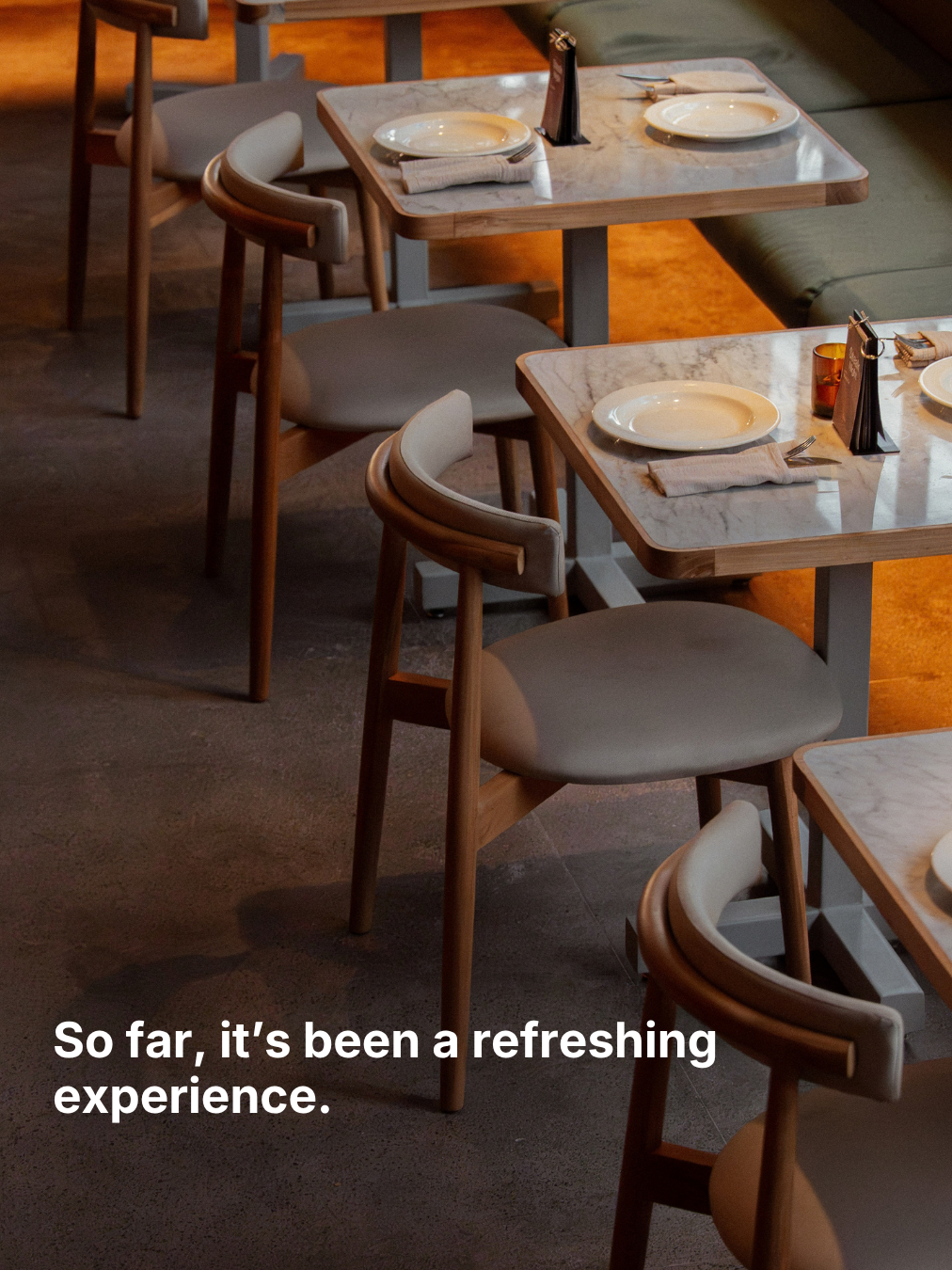 Empty restaurant tables and chairs, with the words “So far, it's been a refreshing experience.”