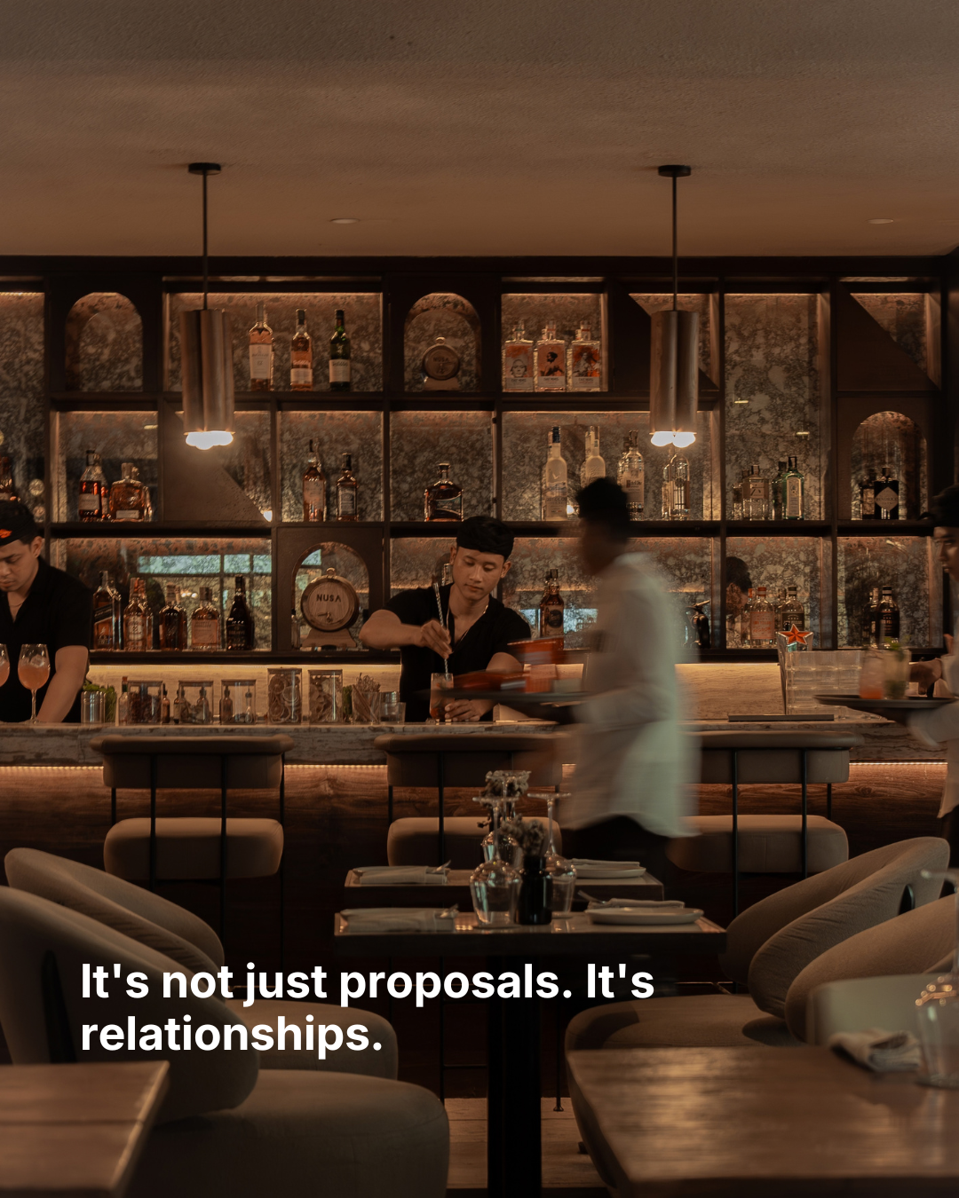 A busy bar at night, with the words “It's not just proposals. It's relationships.”